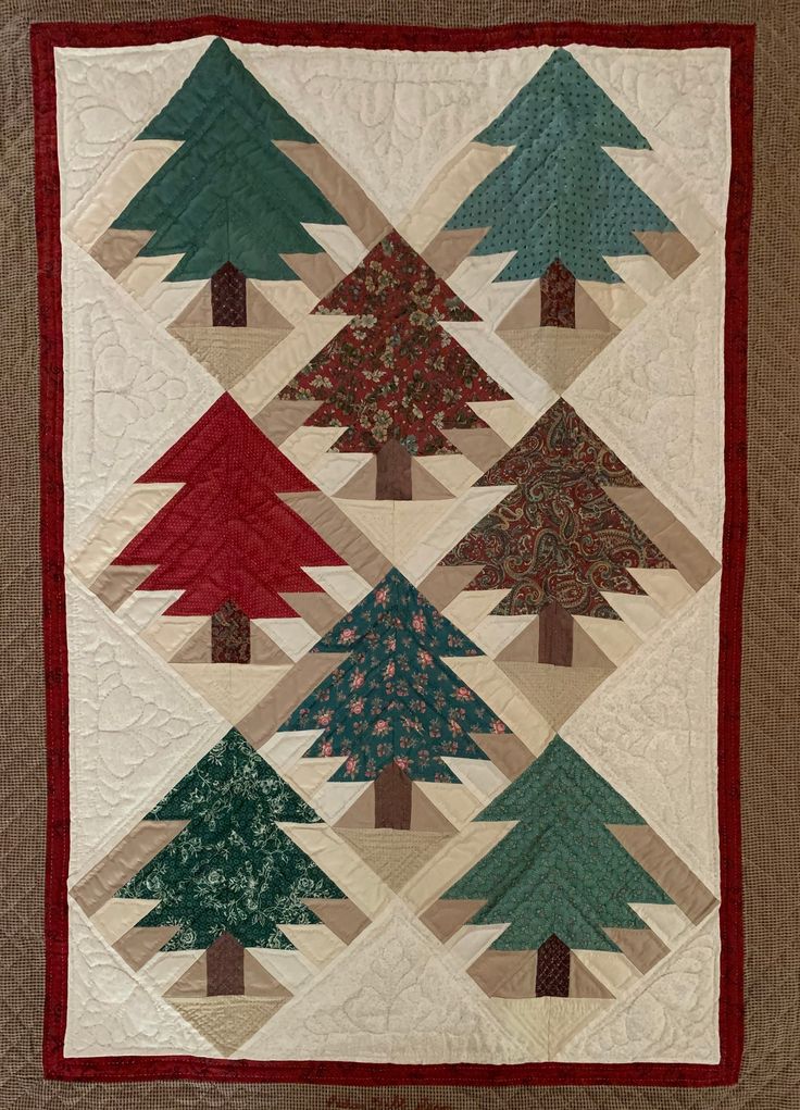 a quilted christmas tree is hanging on the wall