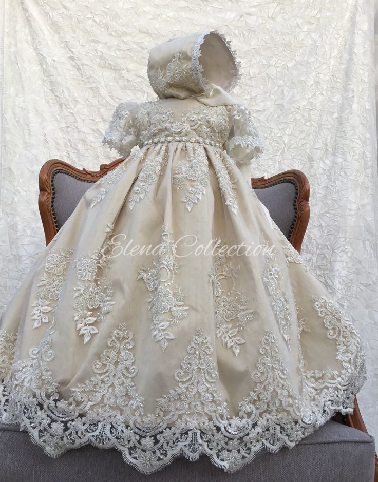 a baby's christ gown is sitting on a chair