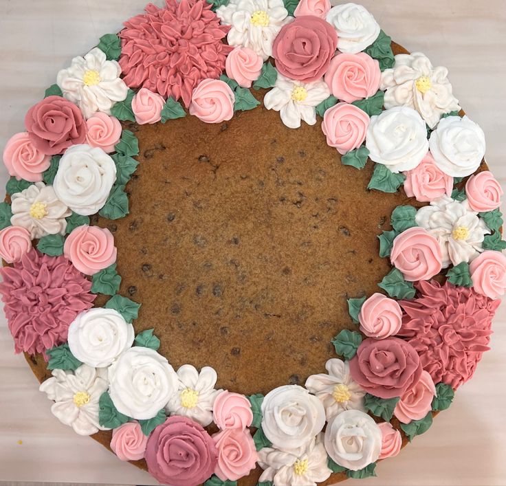 there is a cake decorated with flowers on the table and frosting in the shape of a circle