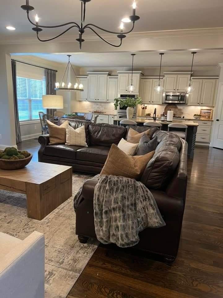 a living room filled with furniture and a kitchen in the backgroung area