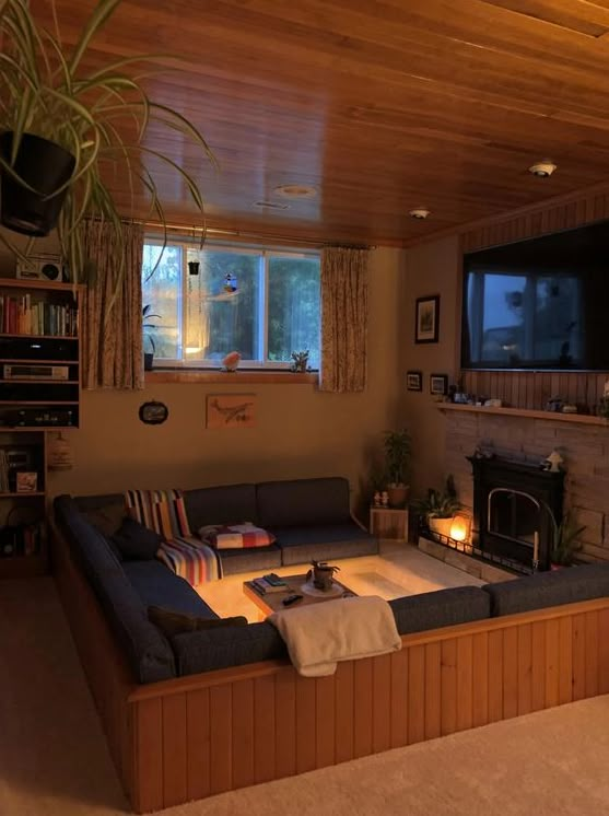 a living room filled with furniture and a flat screen tv mounted on the wall next to a fire place