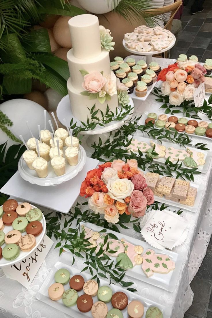 a table topped with lots of different types of desserts and cupcakes on top of plates