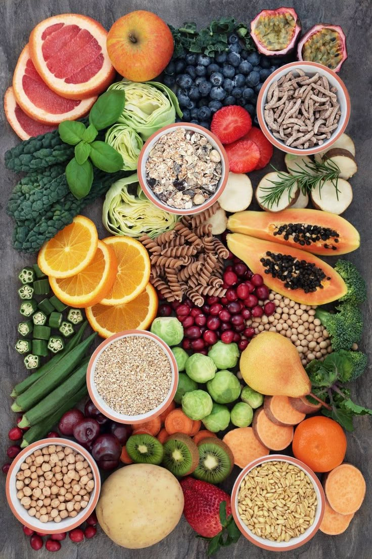 an array of fruits and vegetables are arranged in the shape of a pyramid on a table