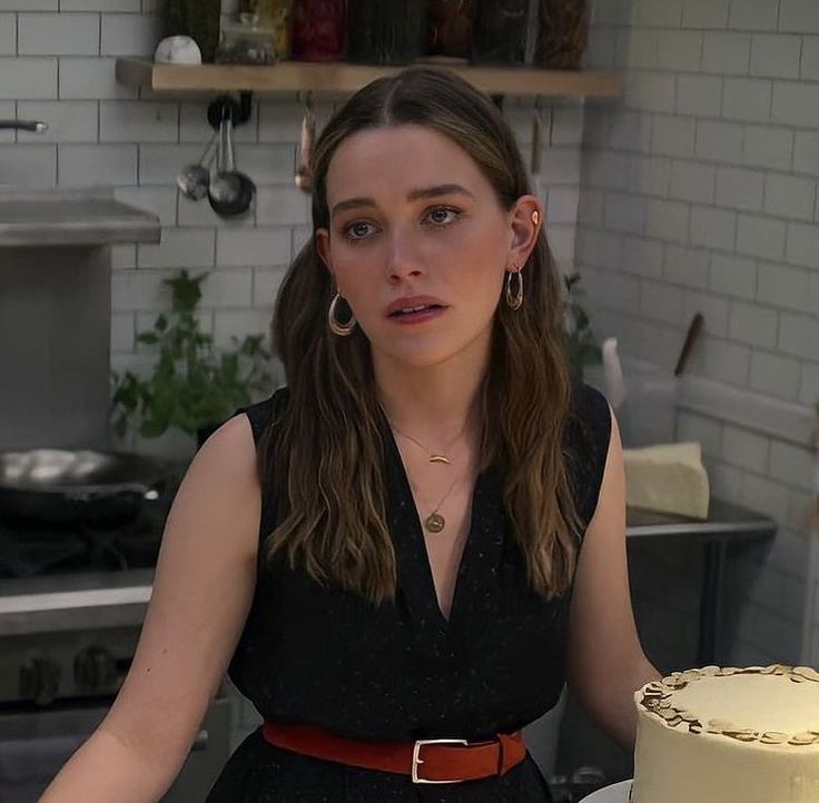 a woman sitting in front of a cake