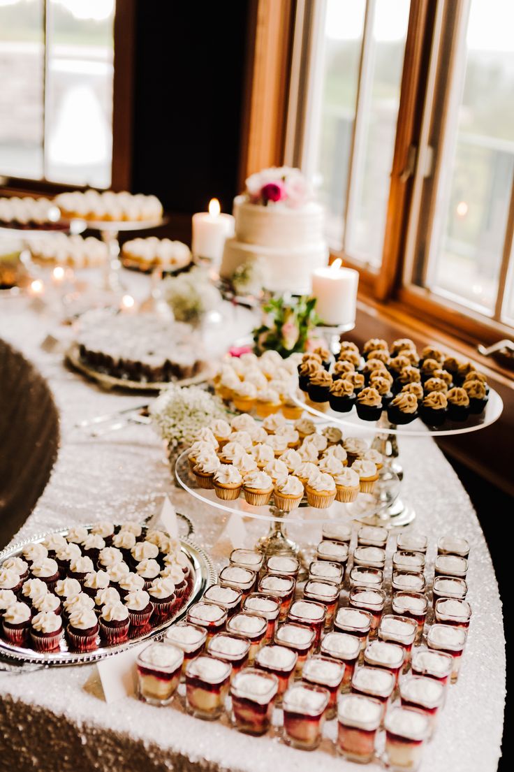 a table topped with lots of desserts and cupcakes on top of plates