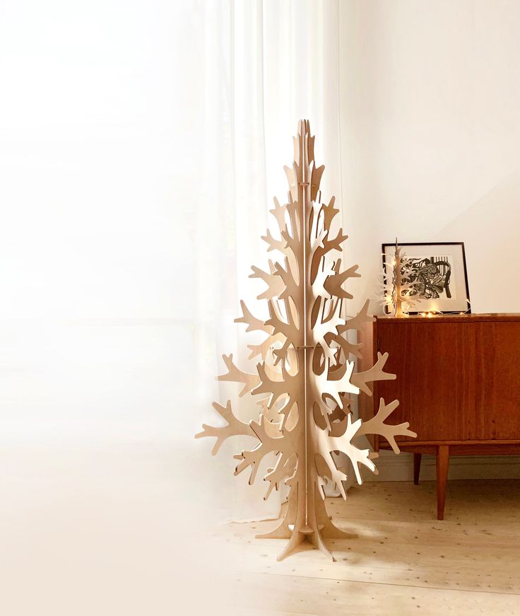 a tall wooden tree sitting next to a dresser on top of a hard wood floor