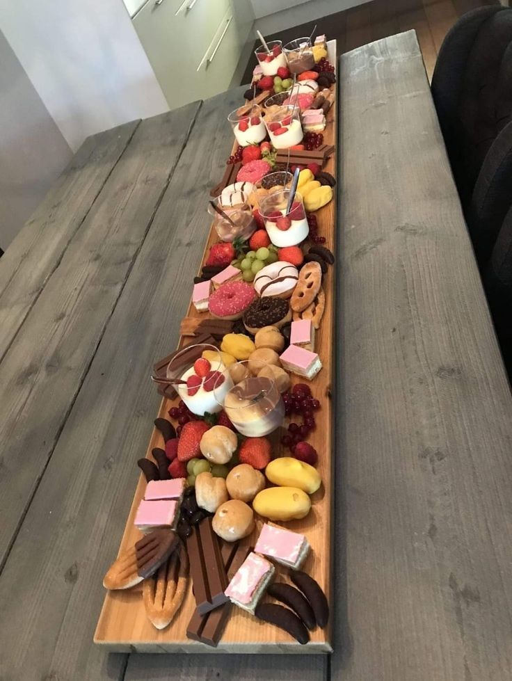 a long wooden table topped with lots of desserts