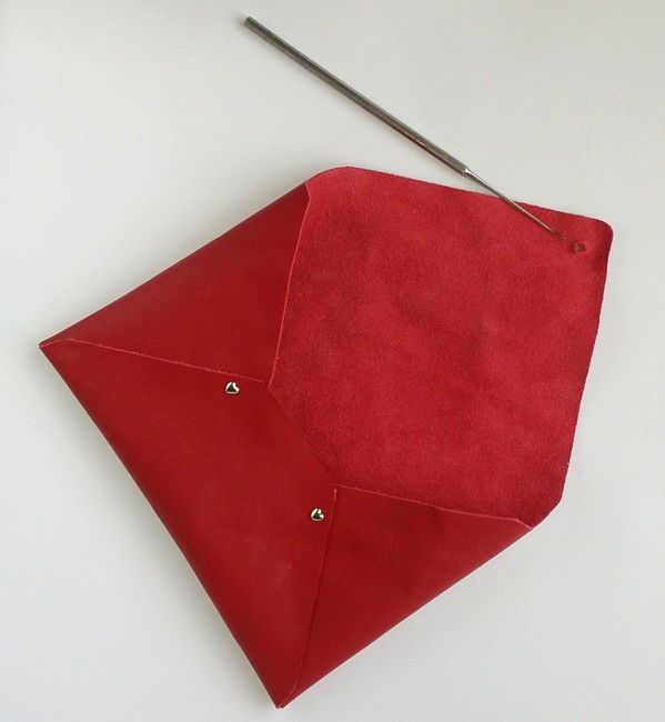 a red piece of cloth with a needle sticking out of it