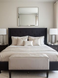 a bed with white sheets and pillows in a bedroom next to two lamps on either side of the bed