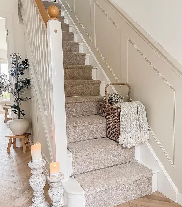 the stairs in this home are decorated with candles and blankets, along with two wicker baskets