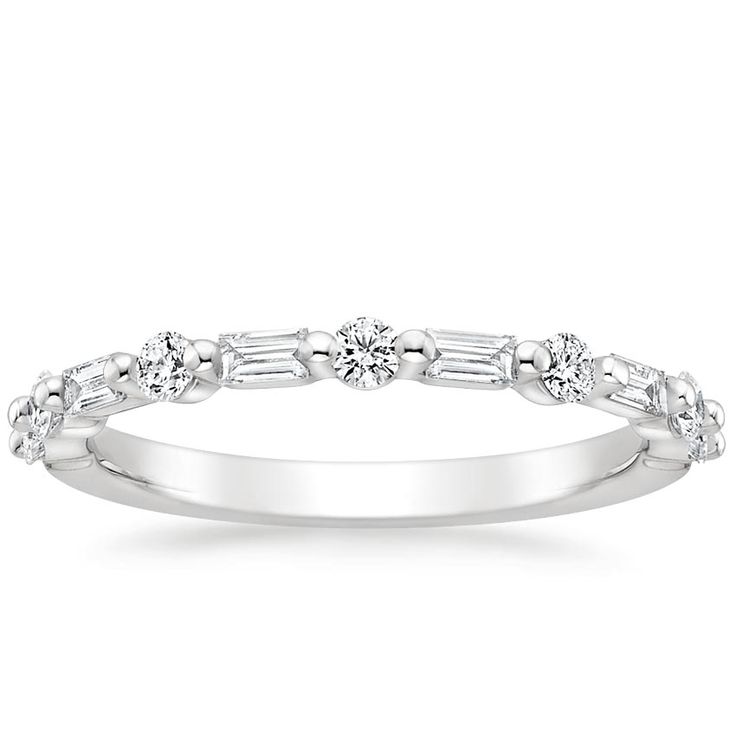 a white gold wedding ring with baguetts on the sides and diamonds in the middle