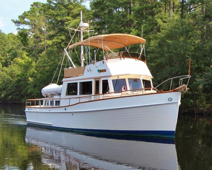 a large white boat floating on top of a lake next to trees in the background