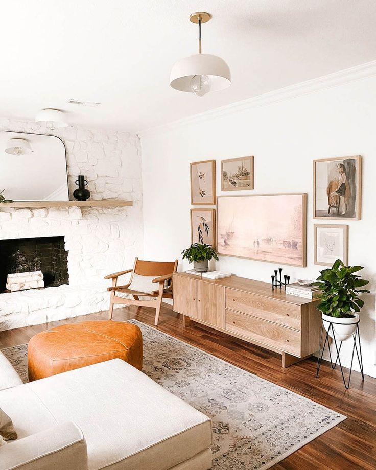 a living room filled with furniture and a fire place in the middle of it's wall