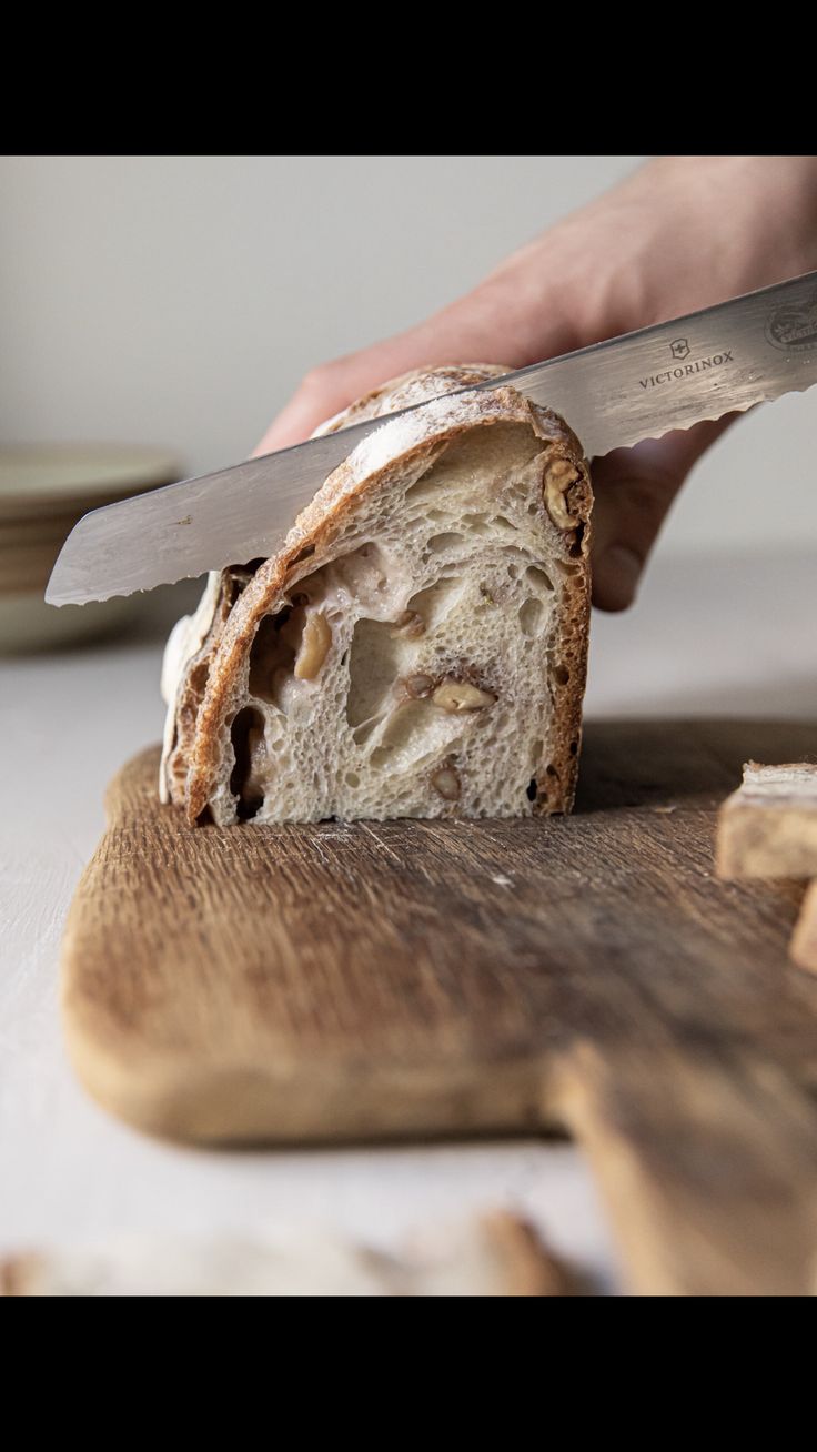 a person is cutting bread with a knife