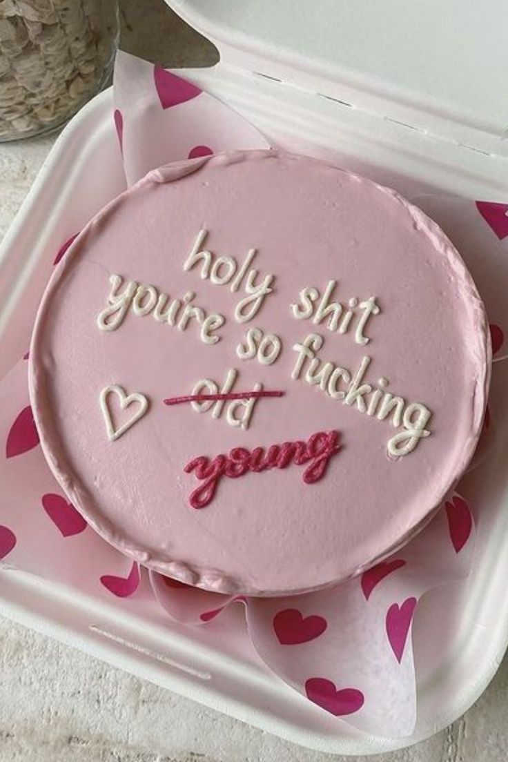 a pink cake sitting on top of a plastic container