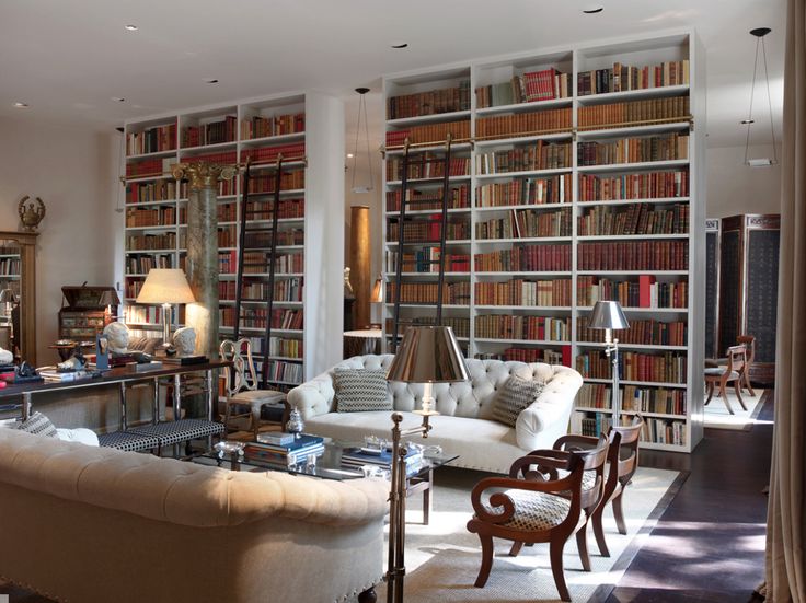 a living room filled with lots of furniture and bookshelves next to each other