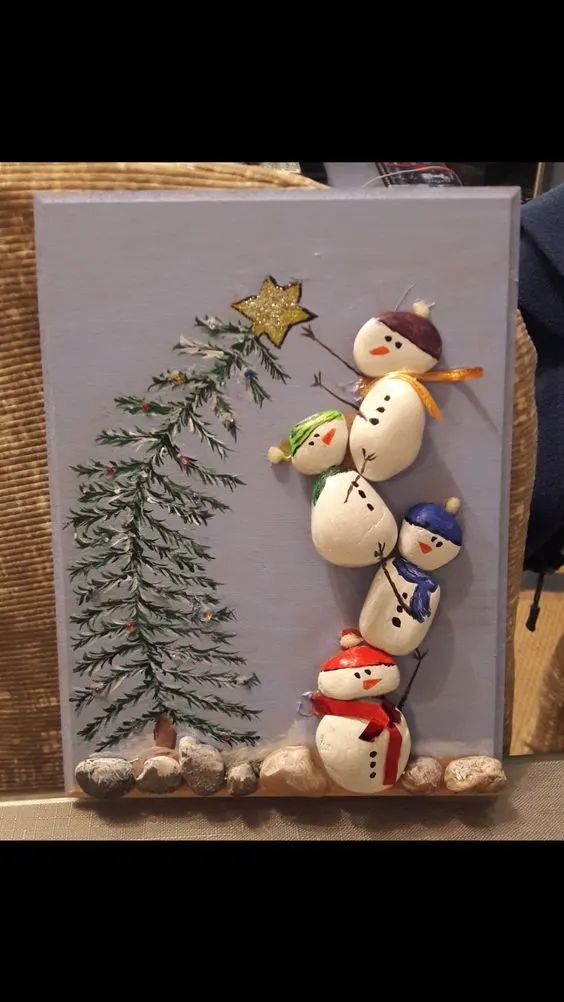 a snowman family with a christmas tree on it's head is standing in front of a painting