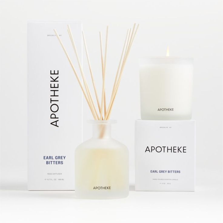 an apothhere candle next to its box and packaging on a white background