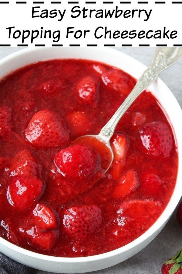 strawberry topping for cheesecake in a white bowl with spoon and strawberries on the side