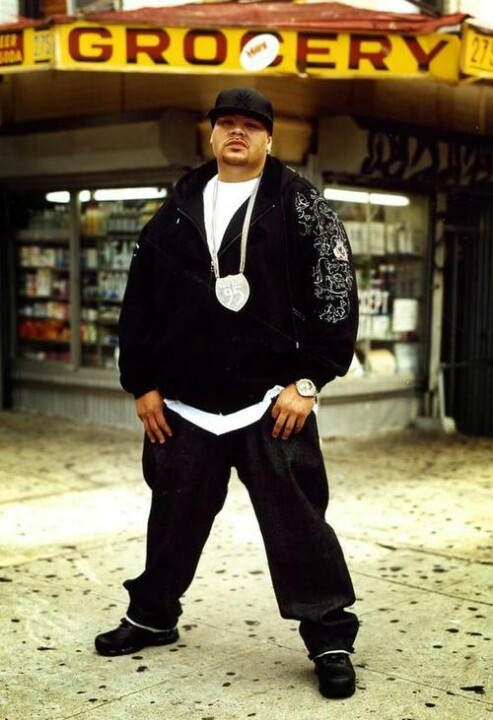 a man standing in front of a grocery store with his hands on his hips and looking at the camera