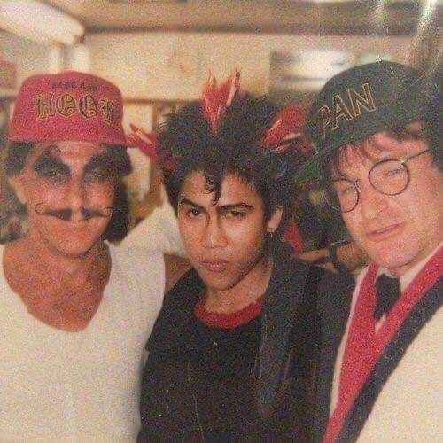 three people with fake moustaches on their faces