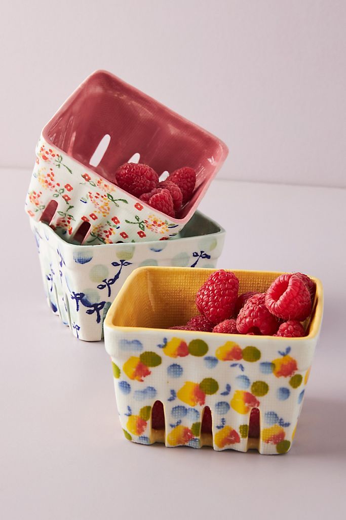 three ceramic containers with raspberries in them