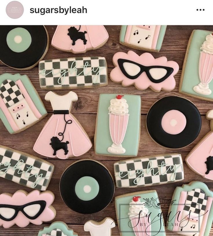 some decorated cookies are sitting on a wooden table with black and white checkerboard