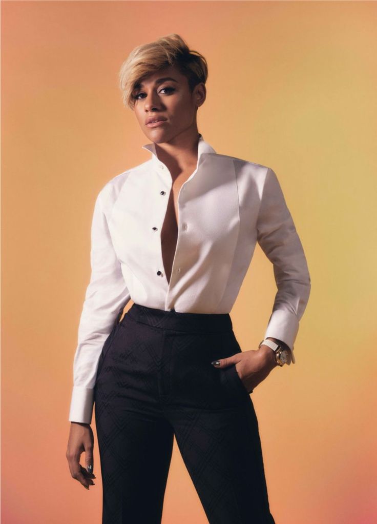 a woman in a white shirt and black pants posing for a magazine cover with her hands on her hips