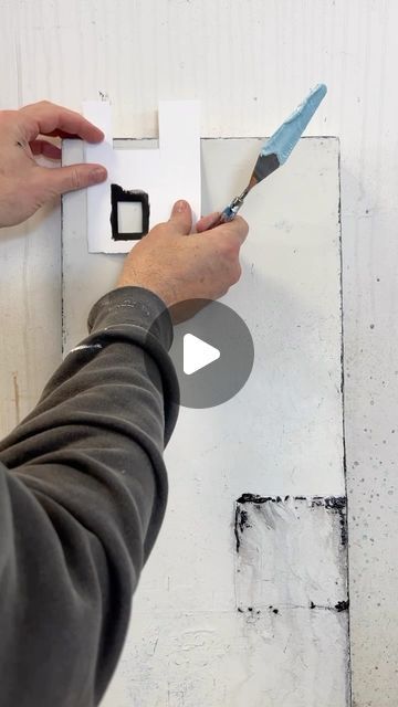 a person is using a pair of scissors to paint the wall