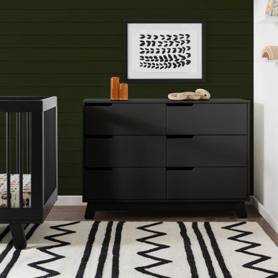 a baby's room with black furniture and green walls