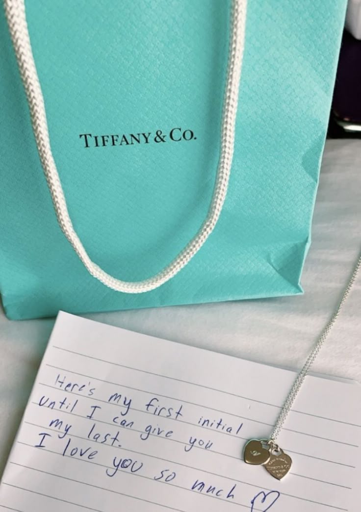 tiffany & co necklace with note and bag on table next to it, which says i love you so much