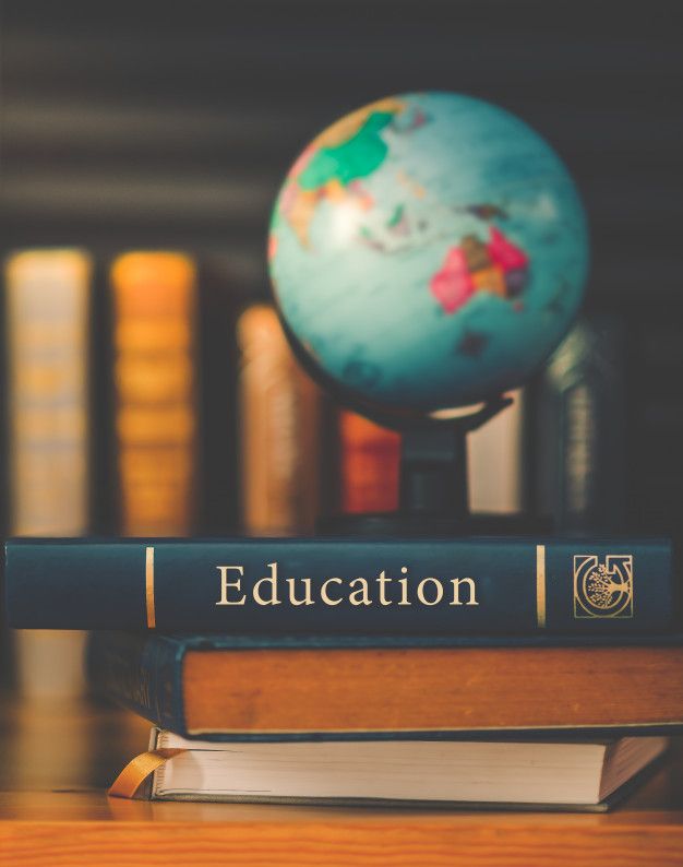 two books sitting on top of each other next to a blue and green globe with the word education written on it