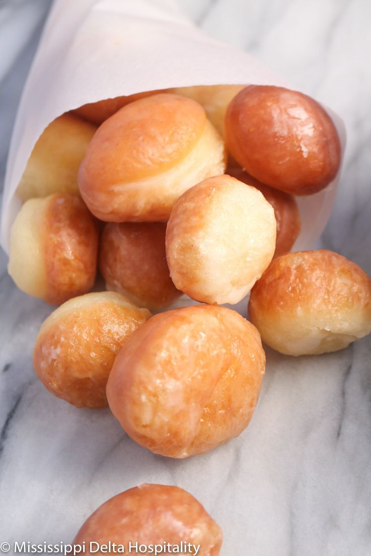 the doughnuts have been placed in a paper bag on the marble countertop