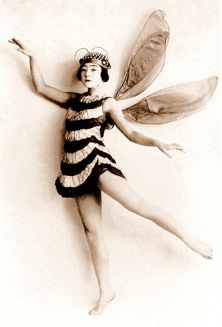 an old photo of a woman dressed as a bee