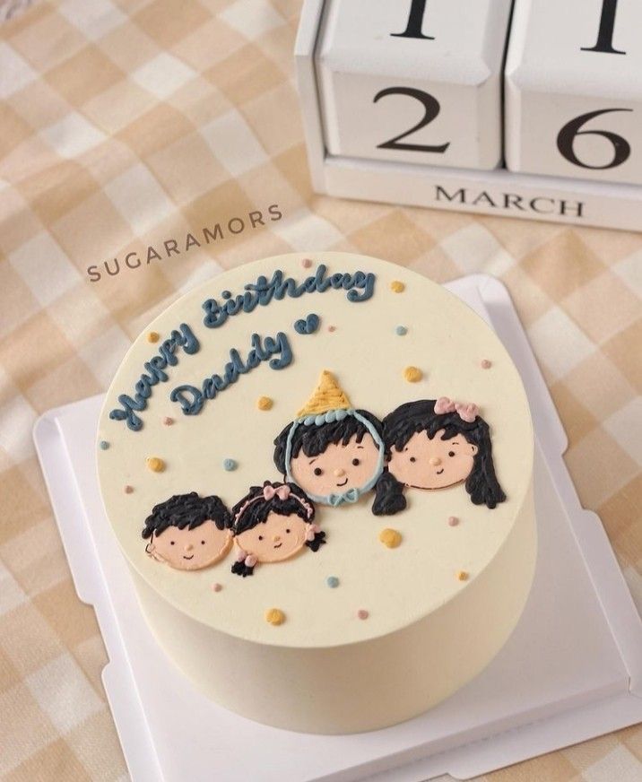 a birthday cake with three children on it sitting on a table next to a clock