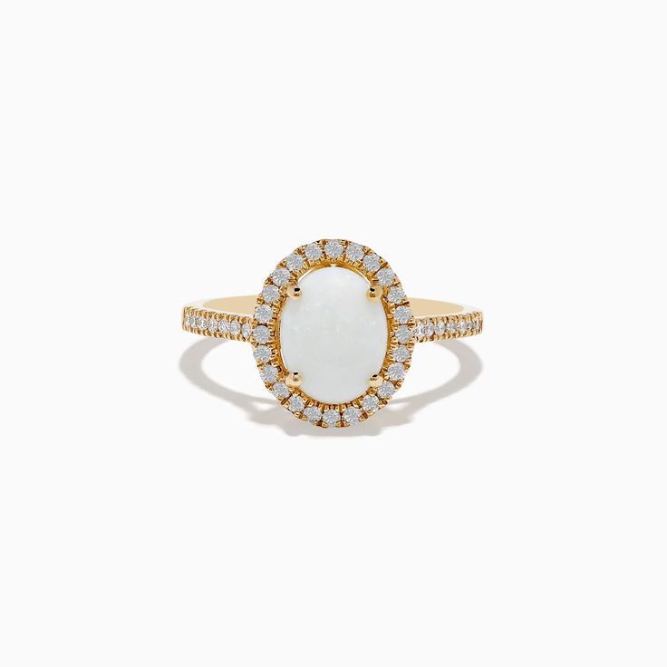 a gold ring with an oval shaped white stone surrounded by small round diamond halos