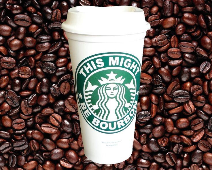 a starbucks cup surrounded by coffee beans