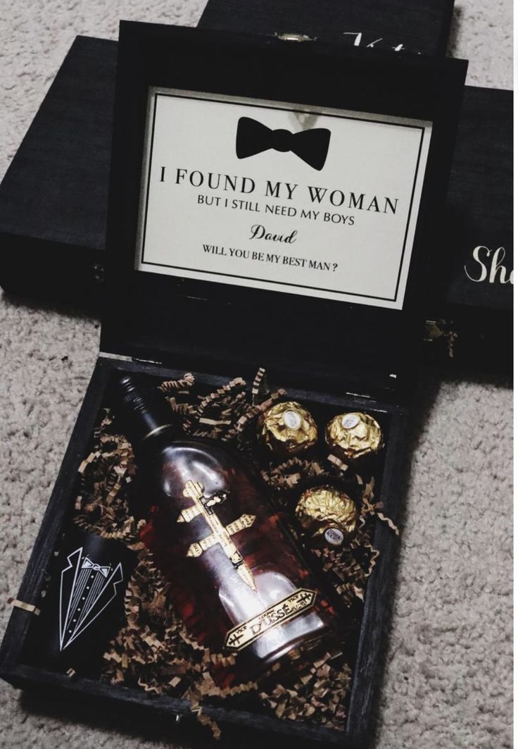 a bottle of wine sitting in a box on the floor next to some chocolates