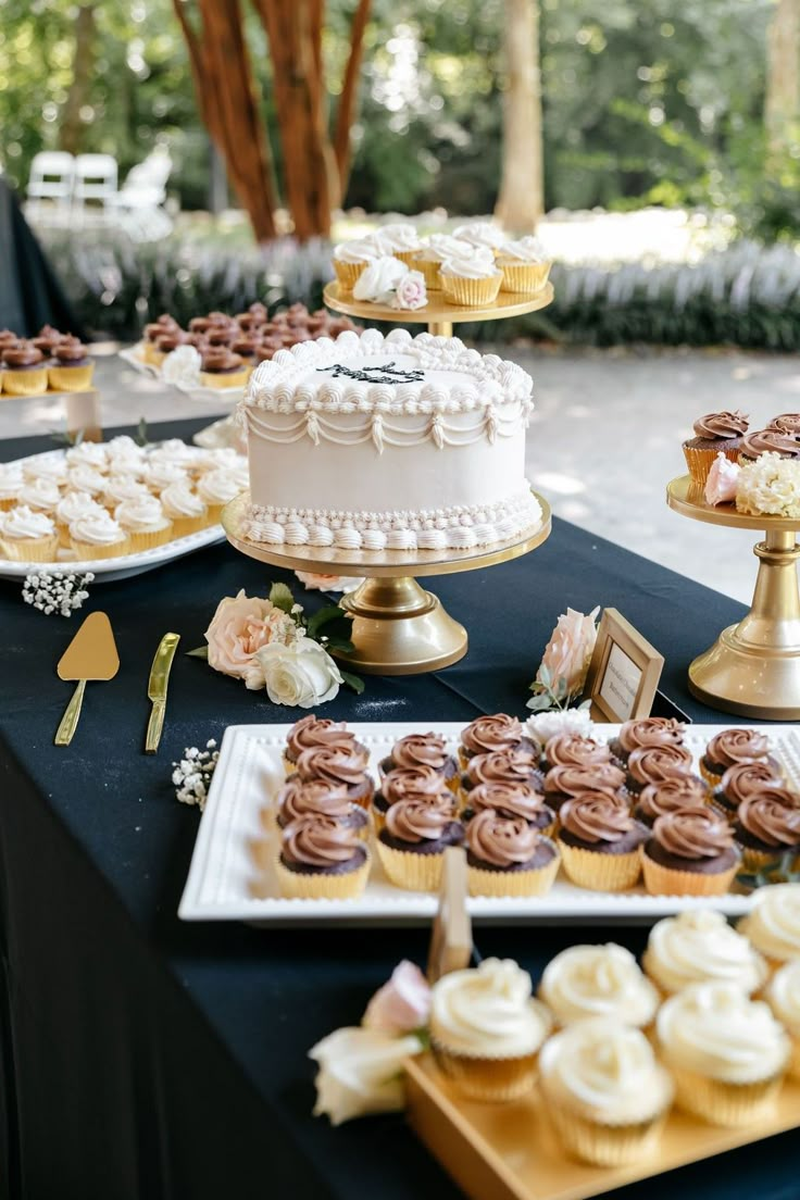 a table topped with cakes and cupcakes next to other desserts on plates