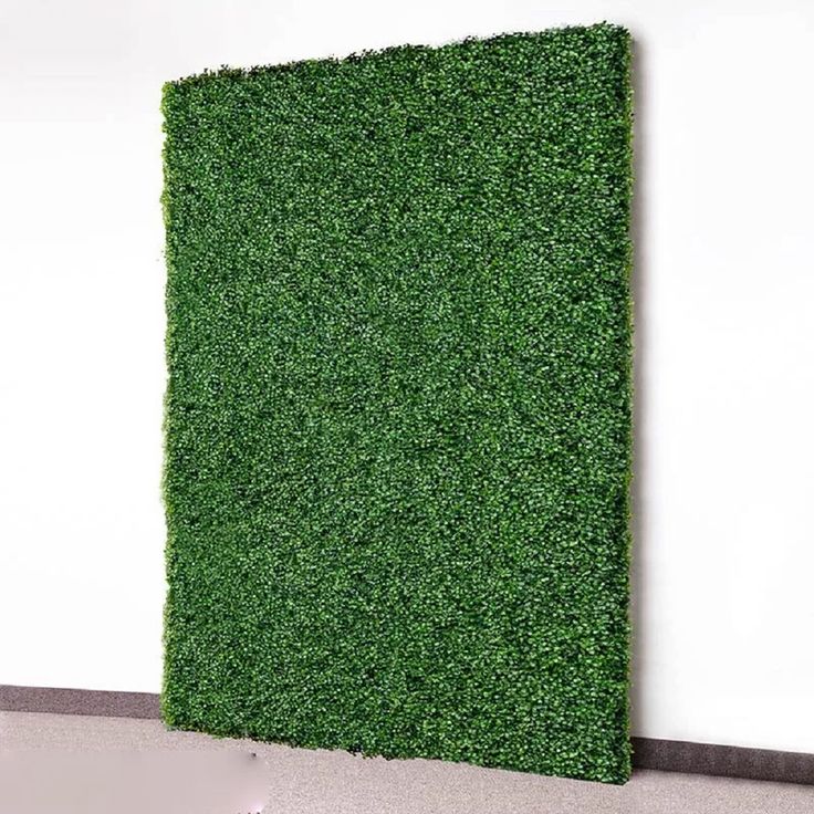 an artificial grass panel in the corner of a room