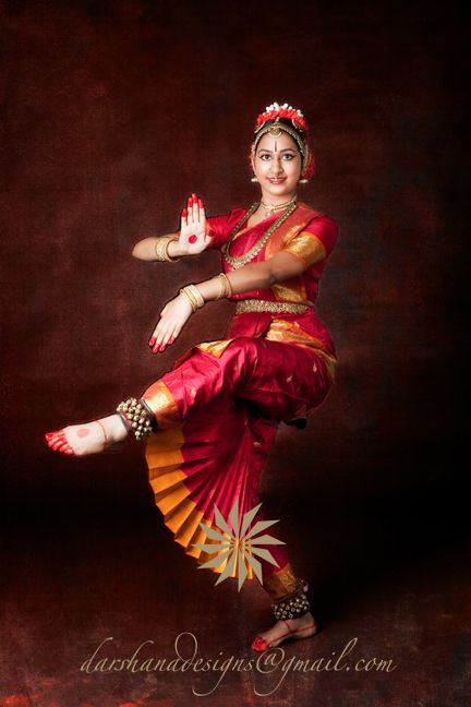 a woman in red and gold is dancing