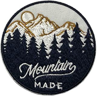 a mountain made patch with trees and mountains in the background, on a white background