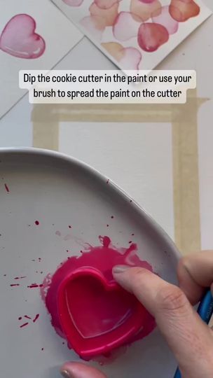 someone is painting hearts on a plate with pink paint