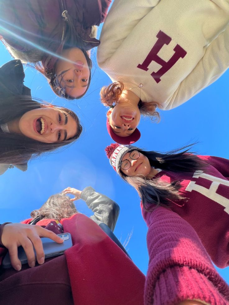 four girls standing in a circle looking up at the camera