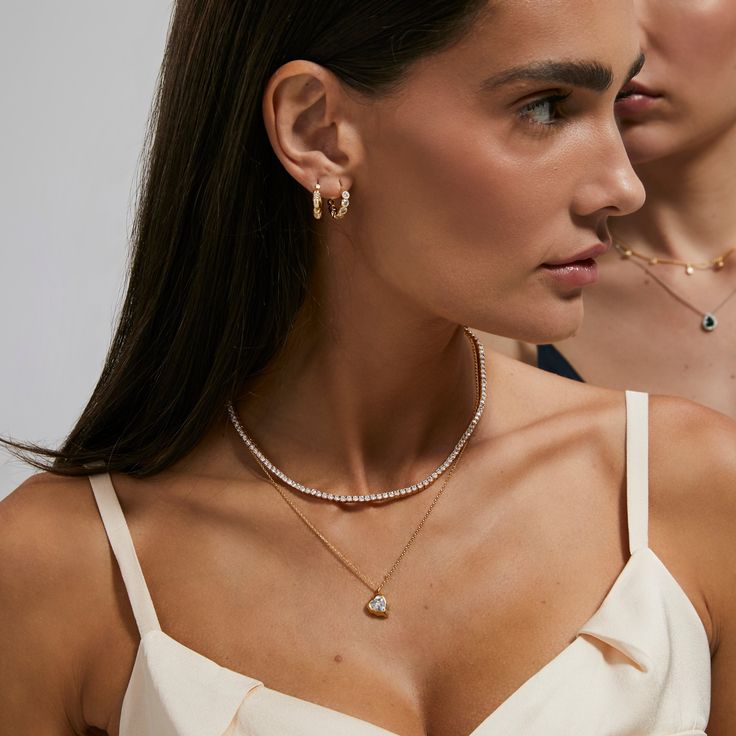 Introducing our Tennis Necklace — a timeless and graceful addition to your jewelry collection. Meticulously crafted to exude sophistication, each perfectly set stone reflects light with a brilliance that captivates. The delicate and continuous line of dazzling gems effortlessly wraps around your neck, creating an aura of refined elegance. Whether paired with an evening gown or to elevate your everyday style, this necklace is the epitome of versatile luxury. Elegant Round Cut Tennis Necklace For Everyday Luxury, Timeless Diamond Cut Necklace For Everyday Luxury, Timeless Everyday Luxury Diamond Cut Necklace, Refined Cubic Zirconia Necklace For Gift, Timeless Tennis Necklace With Diamond Cut For Gift, Timeless Tennis Necklace With Diamond Cut As Gift, Timeless Tennis Necklace With Diamond Accents Gift, Fine Jewelry Diamond Cut Necklace For Everyday Luxury, Timeless Diamond Cut Tennis Necklace As A Gift