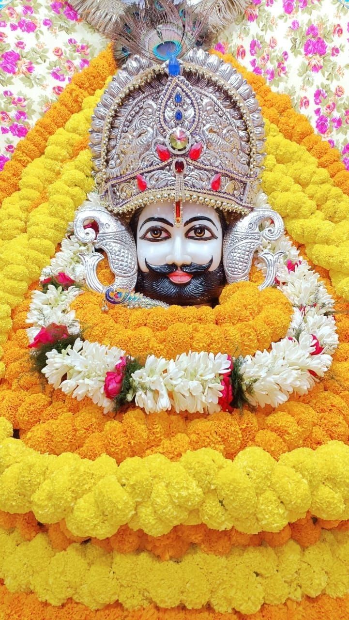 an idol is displayed in the middle of a flowered area with white and yellow flowers