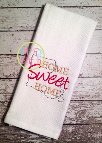 a white towel with the words home sweet home on it sitting on top of a wooden table