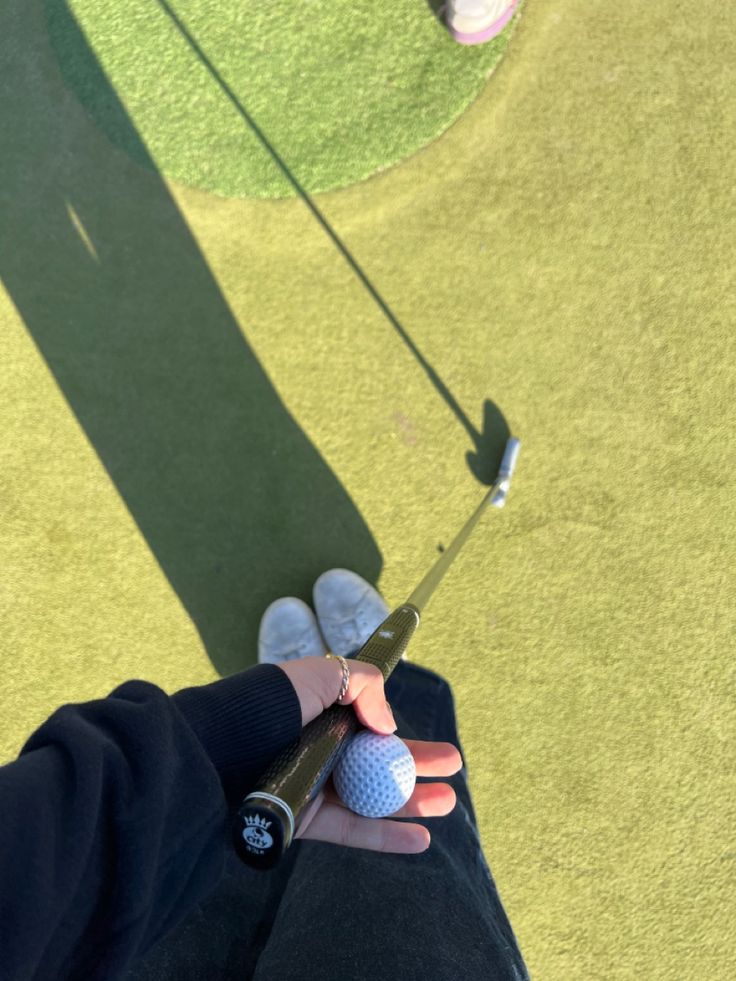 a person holding a golf ball in their hand