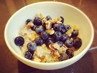 a white bowl filled with blueberries and cereal