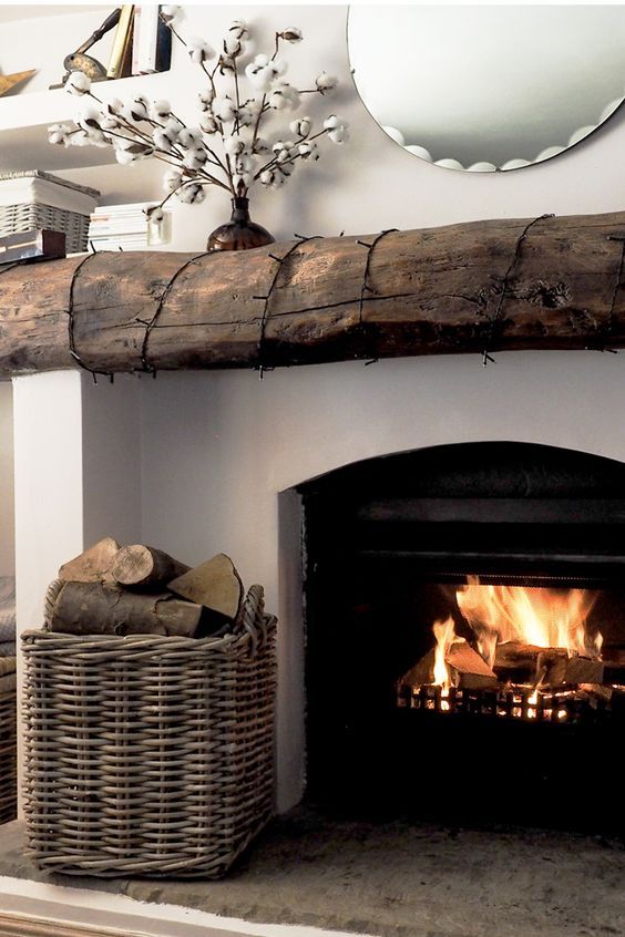 a fireplace with logs and firewood in the center, next to a basket full of logs